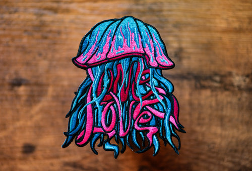 Jellyfish-shaped patch with ' ONE LOVE' text on a wooden background.